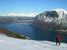 Po vyše hodine dosahujeme hornú hranicu stromčekov, odkiaľ sa nám začína v plnej kráse odkrývať tmavomodrý Innfjorden (na druhej strane fjordu vidieť  vpravo čiernu stenu masívu Grisetskolten, obľúbené miesto basejumperov) - fotil Petr Tomáš