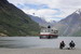 Pohodička na brehoch Geirangerfjordu, ktorým v letnom období každú chvíľu plávajú rôzne typy výletných lodí