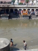 Miestne deti sa počas pohrebného obradu bezstarostne čľapkajú v rieke